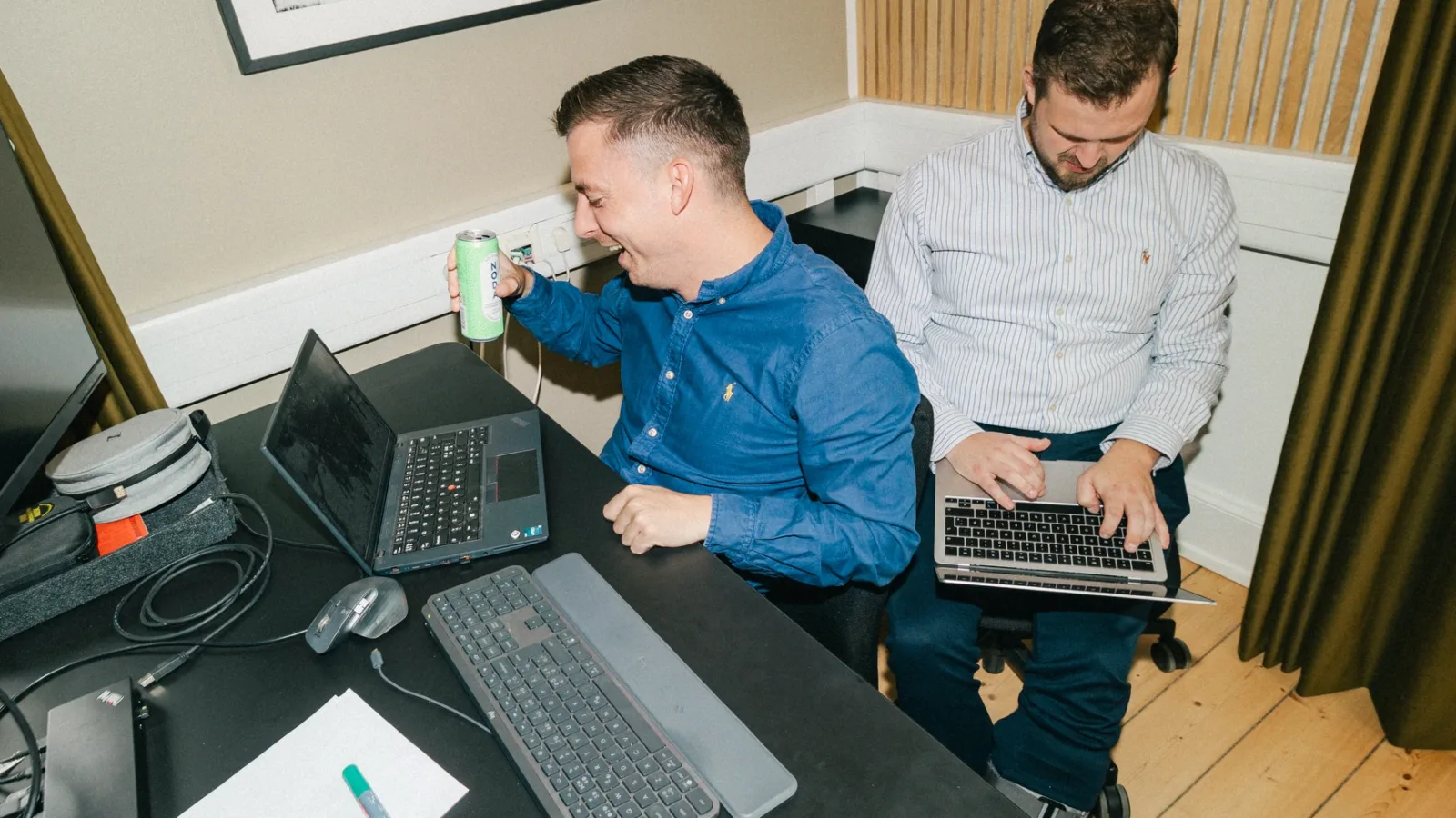 To kolleger arbejder side om side på bærbare computere med GA4 opsætningen