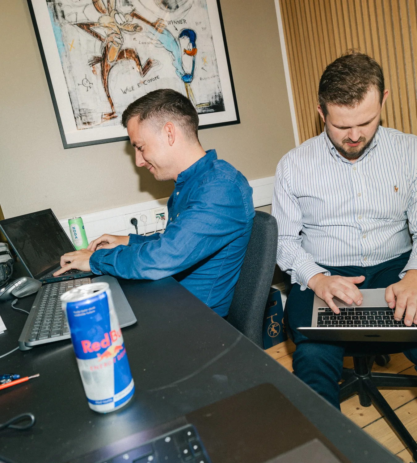 To kolleger arbejder side om side på hver sin bærbare med digital marketing for danske virksomheder