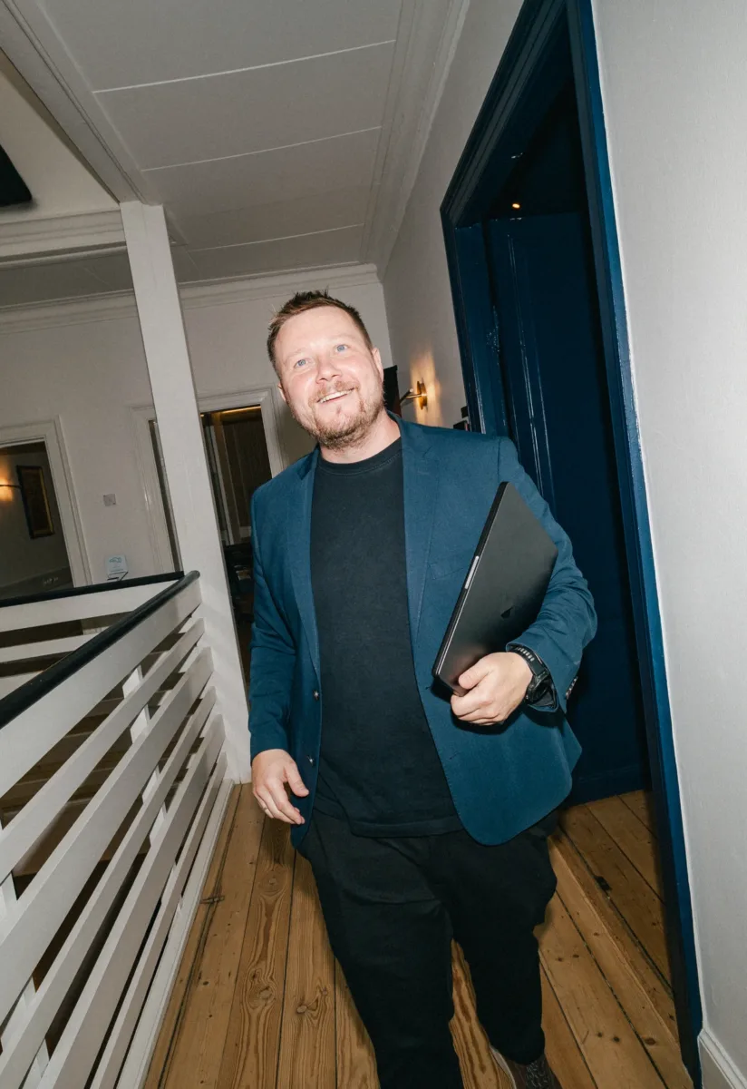 Medarbejder går gennem gangen med den bærbare under armen på kontoret