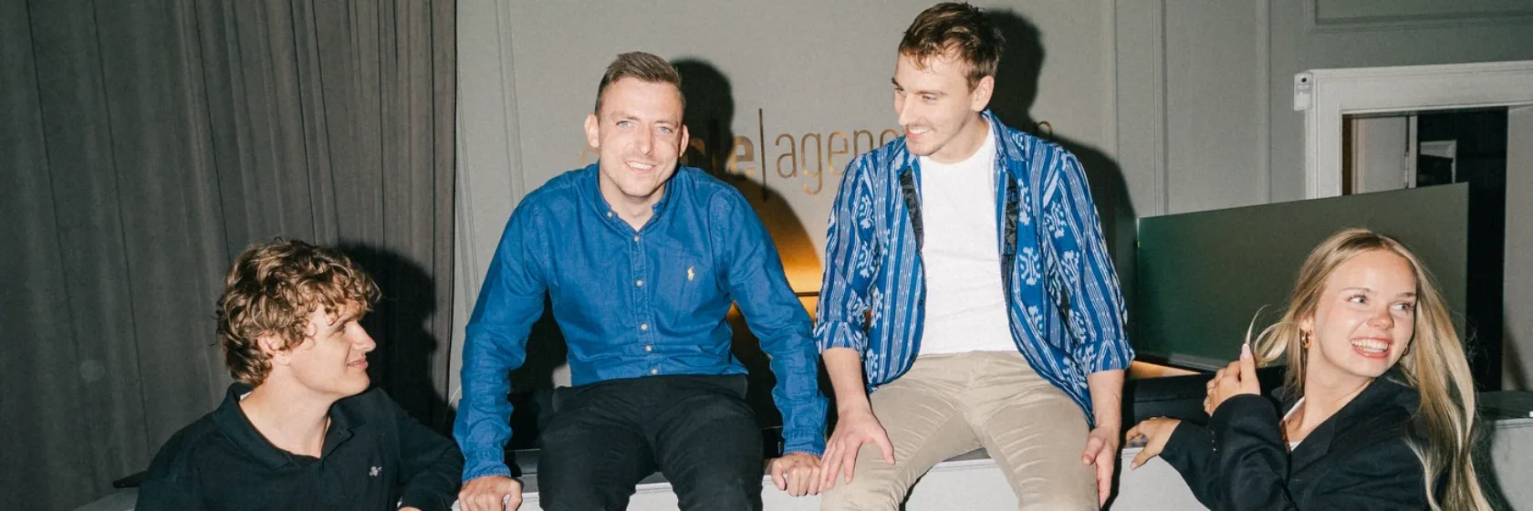 Fire kolleger fra teamet samlet omkring receptionsskranken hos Simple Digital