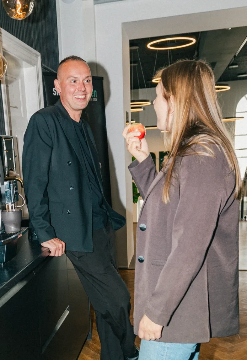 To kolleger taler strategi ved kaffemaskinerne i kontorkøkkenet
