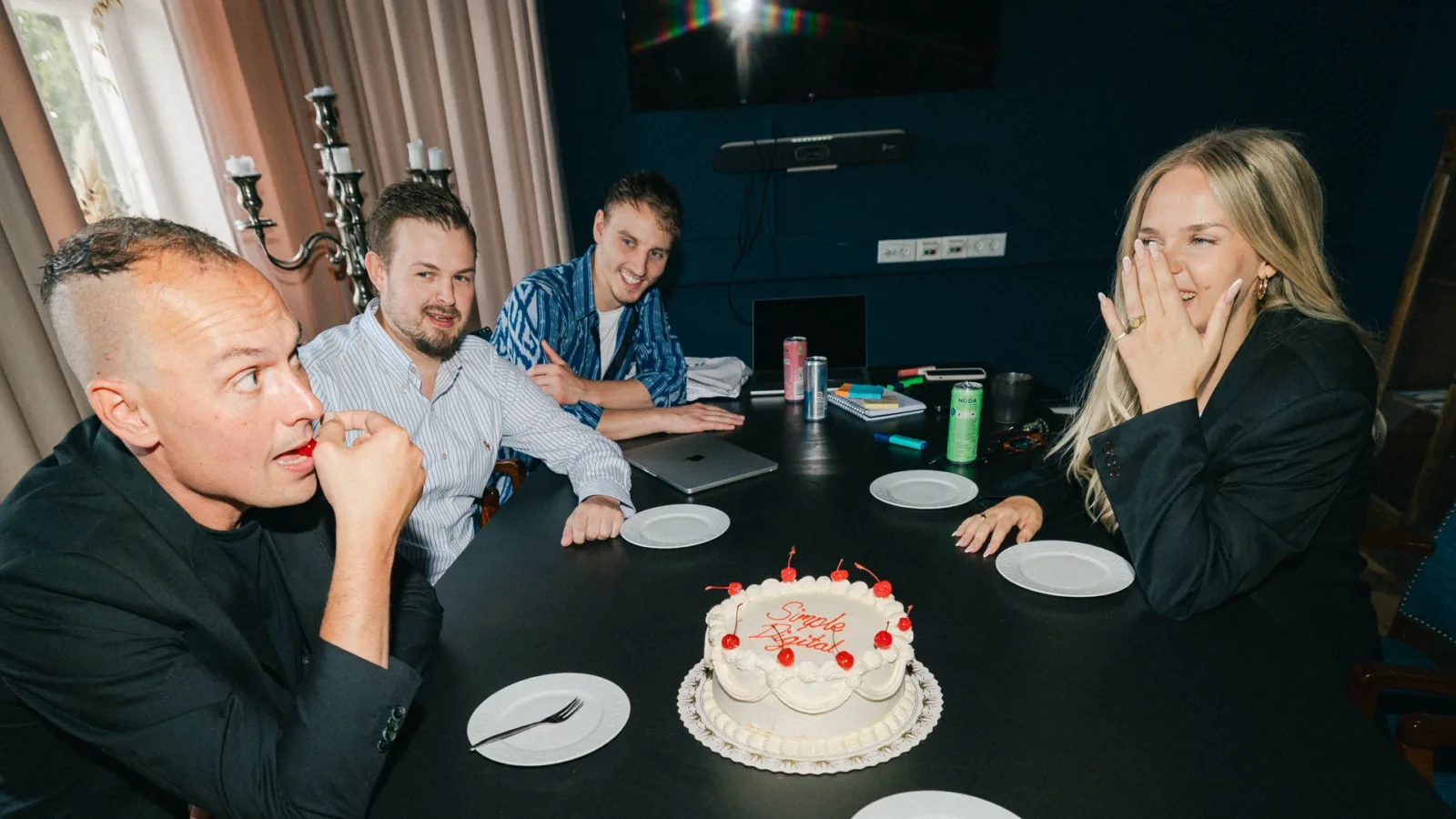 Kolleger fejrer med lagkage i mødelokalet hos teamet bag WordPress udvikling