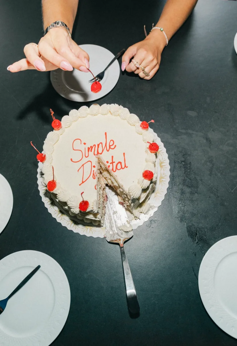 Lagkagen med teksten Simple Digital set fra oven med et stykke skåret ud