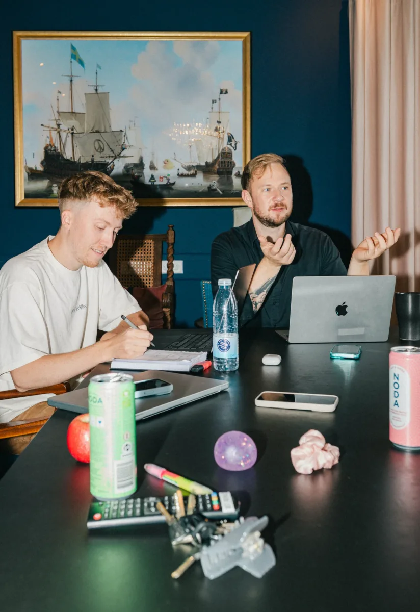 To kolleger gennemgår resultater af WordPress udvikling ved mødebordet, den ene tager noter